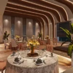Sugee Marina Bay Worli Banquet Hall With Round Tables Upholstered Chairs Flower Centerpieces And Arched Ceiling