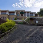 6 BHK Villa Ribandar Panjim North Goa Villa Front Elevation With Stone Walls Wide Driveway And Landscape