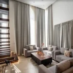 BHK Villa Luxe Riviera Candolim Goa Floating Stair Pebble Base Grey Sofa Curtain Living Room