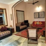 Saudades Beach Bungalow Candolim Goa 3 BHK Arched Bookshelf Red Sofa Living Room