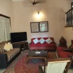 Saudades Beach Bungalow Candolim Goa 3 BHK TV Unit Red Sofa Wrought Iron Staircase Living Room