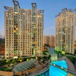 Sheth Vasant Lawns Thane Residential Towers Night View With Illuminated Facade And Podium Amenities
