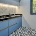 3 BHK Bungalow Green Garden Chembur Mumbai Kitchen Interior With Blue Cabinets Black Countertop Herringbone Tile Backsplash Sink Area