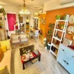 3 BHK Imperial Heights Goregaon West Orange Accent Wall White Ladder Shelf Yellow Cushion Bohemian Living Room