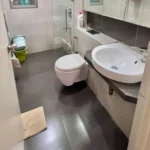 3 BHK Imperial Heights Goregaon West Wall Hung WC Pedestal Sink Dark Tile Floor White Tile Compact Bathroom
