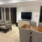 3 BHK Lotus Ananya JVPD Juhu Grey Armchair Wood Dining Table Large TV Open Plan Living Dining