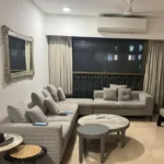 3 BHK Lotus Ananya JVPD Juhu Grey L Shape Sofa Silver Ornate Mirror Round Marble Table Living Room