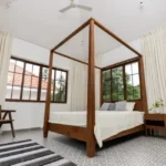4 BHK Villas Elements Nachinola Goa bedroom with garden facing windows wooden framed glass panels patterned floor tiles