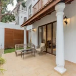 4 BHK Villas Elements Nachinola Goa covered outdoor seating space with wicker chairs tiled patio garden plantation