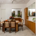 4 BHK Villas Elements Nachinola Goa dining area with wooden dining table woven chairs modular kitchen