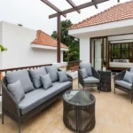 4 BHK Villas Elements Nachinola Goa rooftop terrace seating area with outdoor wicker furniture pergola design tiled flooring and open sky view