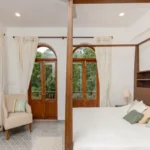 4 BHK Villas Elements Nachinola Goa spacious bedroom interior with four poster wooden bed tiled flooring