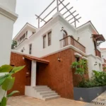 4 BHK Villas Elements Nachinola Goa villa entrance and side elevation with textured exterior walls balcony spaces