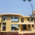 7 BHK Villa Panchgani Mahabaleshwar Exterior Front Elevation Showing Modern Two Floor Structure With Curved Balcony Large Glass Windows And Open Terrace Staircase