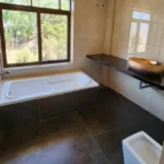 7 BHK Villa Panchgani Mahabaleshwar Interior Bathroom With Bathtub Large Window Outdoor Greenery View Stone Flooring
