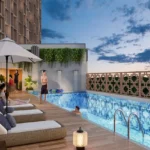 Isle Of Calm Powai rooftop swimming pool with deck loungers and evening skyline ambiance
