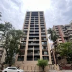 Lotus Ananya JVPD Juhu Warm Stone Facade Dark Glass Balcony Street Level Exterior