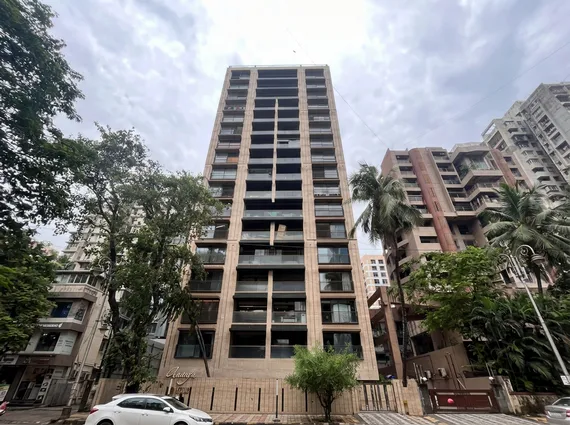 Lotus Ananya JVPD Juhu Warm Stone Facade Dark Glass Balcony Street Level Exterior