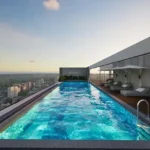 Mehta Marquina Goregaon East rooftop infinity swimming pool with lounge beds and panoramic skyline sunset views