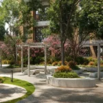 Piramal Revanta Mulund West White Pergola Circular Stone Bench Pink Blooming Tree Pebble Path Landscape Garden