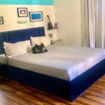 3 BHK Kuvar House Colaba Bedroom with Blue Bed and Wooden Floor