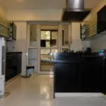 5 BHK Lake Superior Powai Kitchen with Black Cabinets and Utility Door