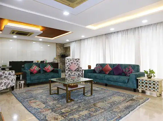 5 BHK Lake Superior Powai Living Room with Blue Sofa and Curtains
