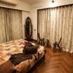 4 BHK Lake Front Solitaire Powai Bedroom with Wooden Flooring and Curtains