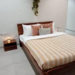 4 BHK Villa Khopoli Bedroom with Striped Bedding and Wooden Headboard