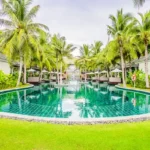 Taj Mount Kusur Villas Resort Swimming Pool Lined with Palms and Villas