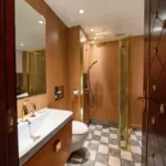 3 BHK Asmi Legacy Unnat Nagar Goregaon Elegant Toilet With Warm Wood Paneling And Brass Fixtures