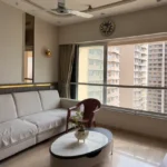 3 BHK Kalpataru Radiance Goregaon Sunlit Lounge With Cream Couch Oval Center Table