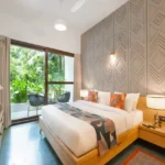 3 BHK Mayberry Villas Anjuna Goa Premium Bedroom With Geometric Accent Wall Balcony Seating And Garden Views