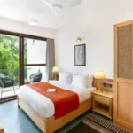 3 BHK Mayberry Villas Anjuna Goa Serene Room With Floor To Ceiling Windows Overlooking Tropical Foliage