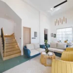 3 BHK Mayberry Villas Anjuna Goa Bright Lounge With Wooden Staircase Yellow Accent Chairs And Pendant Lighting