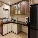 4 BHK Cannon Bandra West Warm Toned Cooking Area With Granite Counter Overhead Storage And Steel Refrigerator