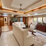 4 BHK Cannon Bandra West Grand Drawing Room With Wingback Seating Carved Wood Furniture And Cove Lighting