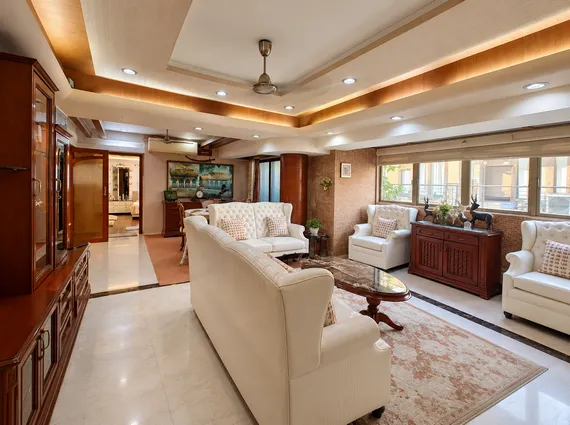 4 BHK Cannon Bandra West Grand Drawing Room With Wingback Seating Carved Wood Furniture And Cove Lighting
