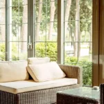 4.5 BHK Isprava Lumosa Aldona Goa Sunroom With Wicker Sofa And Garden Views