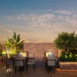 Ivory Heights Vile Parle Sunset Open Air Rooftop Dining With Tropical Planters And Bird Sky
