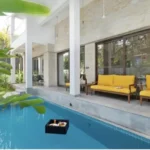Mayberry Villas Anjuna Goa Villa Pool Area With Stone Cladded Exterior Yellow Lounge Sofa