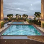 One Vara Goregaon Rooftop Swimming Pool Illuminated At Dusk With Sweeping City Skyline Views